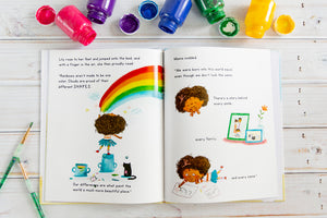 Lily May and the Ruby Shoes Blues book is open onto a page where Lily May is painting a rainbow and talking about diversity.